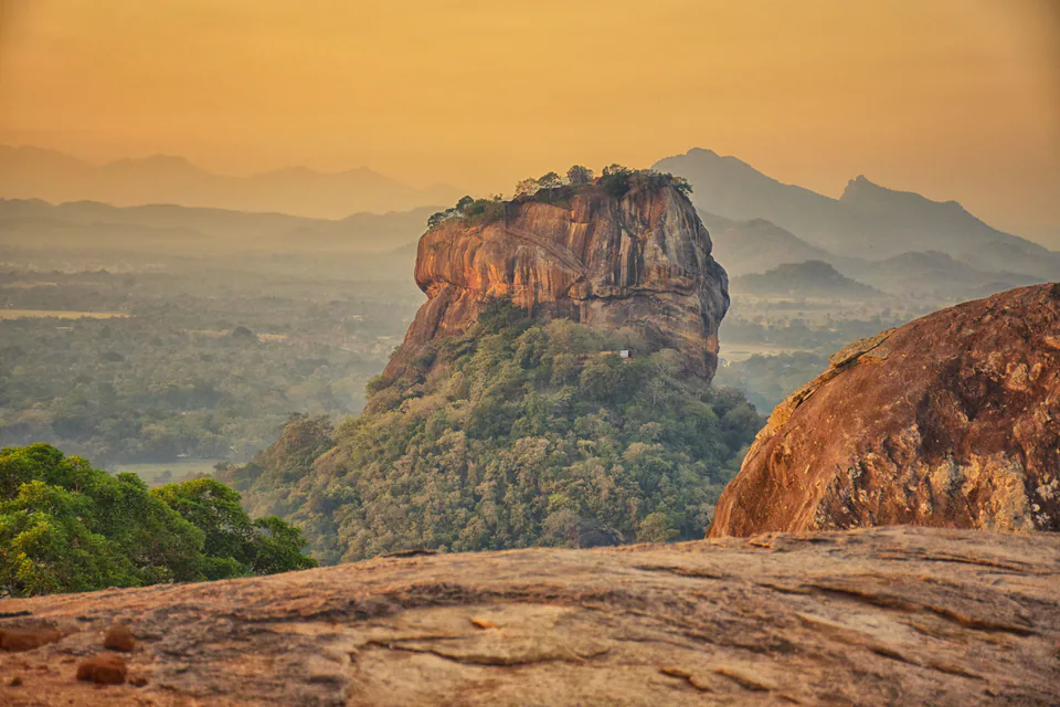 Sigiriya rock fortress rising above the forest at golden hour, seen from Pidurangala